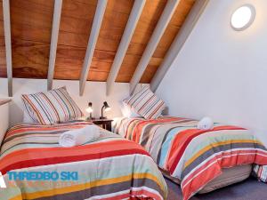 2 Betten in einem Zimmer mit Holzdecken in der Unterkunft Granite Peaks 2 in Thredbo