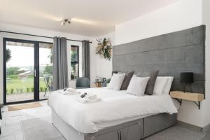 een slaapkamer met een groot bed en een groot raam bij The Old House 1147 in Bridgend