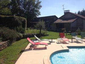 een groep ligstoelen en een zwembad bij Le gîte du mas avec piscine in Bourganeuf