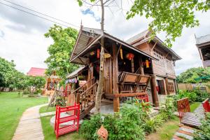 a tree house with red chairs in front of it at HEYUAN in Chiang Mai