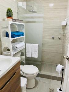 uma casa de banho branca com um WC e um chuveiro em Casa Tonsupa Club del Pacifico em Tonsupa