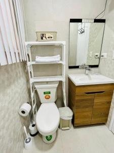 uma casa de banho com um WC branco e um lavatório. em Casa Tonsupa Club del Pacifico em Tonsupa