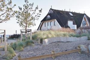 a house with a black roof on a beach at Appartement im Haus Deichgraf in Dahme
