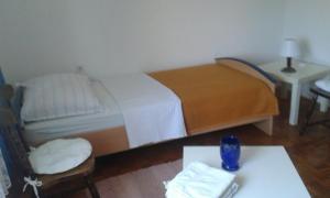 a small bedroom with a bed and a table at Apartman Brazil in Bihać