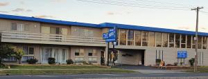 um grande edifício com um telhado azul numa rua em Morwell Parkside Motel em Morwell