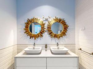 a bathroom with two sinks and mirrors on the wall at Facing Bay Hostel in Praia da Vitória