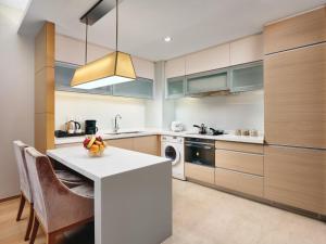 a kitchen with a white counter and a dishwasher at Grand ParcVue Hotel Residence Chengdu in Chengdu