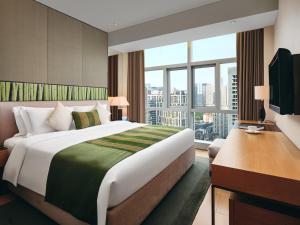 a bedroom with a large bed and a large window at Grand ParcVue Hotel Residence Chengdu in Chengdu