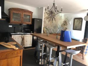 a kitchen with a wooden table with stools at La petite maison dans la jungle in Chartres-de-Bretagne