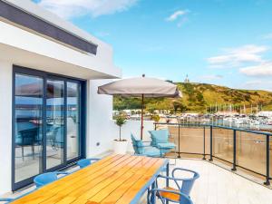 a balcony with a table and chairs and a view of the ocean at Facing Bay Hostel in Praia da Vitória