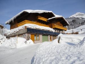 a building covered in snow with a pile of snow at Haus Gappmaier in Filzmoos