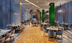a restaurant with tables and chairs and green columns at Wanda Vista Istanbul in Istanbul