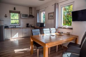 a kitchen and dining room with a wooden table and chairs at Dom Morski in Lubiatowo