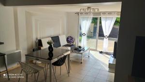 a living room with a table and chairs and a couch at Jolie maison avec Jardin à Réau in Réau