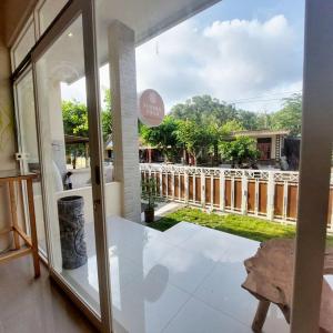a room with a glass door with a view of a yard at Summerfield Homestay and Cafe in Pacitan