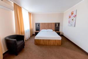 クラマトルスクにあるHotel "Kramatorsk"のベッドルーム1室(ベッド1台、椅子付)