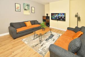 a living room with two couches and a table at Alexandra Terrace by YourStays in Crewe