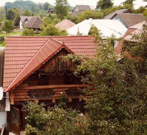 uma cabana de madeira com um telhado vermelho em Kotedzh Smereka em Kelechin