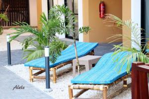 a couple of benches sitting next to a building at Magnifique Appartement au coeur de la Senegambia Kololi in Banjul