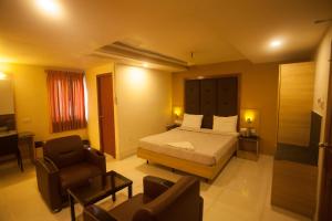 una camera con letto, divano e sedie di P K Rresidency a Madurai