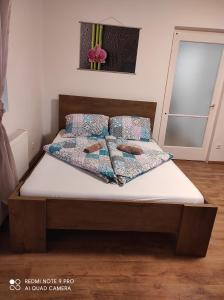 sypialnia z łóżkiem z białą pościelą i poduszkami w obiekcie Kamilla Vendégház w mieście Sárospatak