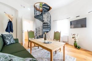 a living room with a table and a spiral staircase at Residenz Schloss Pöggstall in Pöggstall