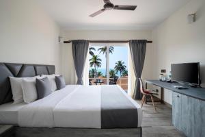 a bedroom with a large bed with a view of the ocean at Stone Wood Beach Resort, Vagator in Vagator