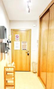 a hallway with a wooden door with a sign on it at La Xouba in Rianjo