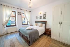 - une chambre avec un lit et 2 fenêtres dans l'établissement Old Town Suites Brașov, à Braşov