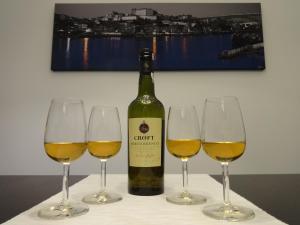 een fles wijn en drie wijnglazen op een tafel bij Live, Love & Feel Porto in Porto
