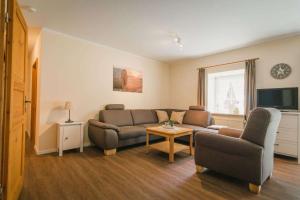 a living room with a couch and a table at Hof Böhmetal in Schneverdingen