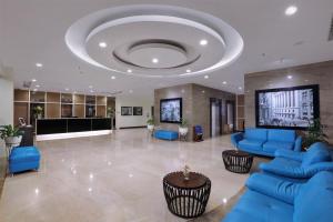 a lobby with blue furniture and a large ceiling at Vega Hotel Gading Serpong in Serpong