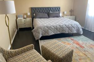 1 dormitorio con 1 cama, 1 silla y 1 sofá en Ed's Englewood Well Furnished Home, en Englewood