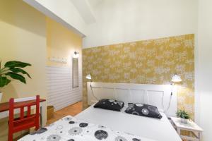 a bedroom with a white bed and a yellow wall at Hostel Elf in Prague