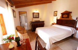 a bedroom with a bed and a table with a bottle of wine at Son Malero in Calvià