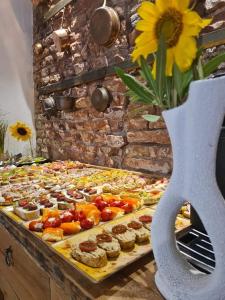 un buffet con muchos tipos diferentes de comida y un jarrón con una flor en CASA GRINDA en Sibiu