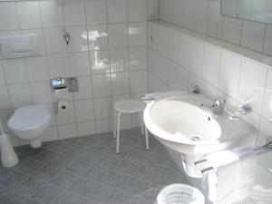a white bathroom with a sink and a toilet at Ferienwohnungen Eleonore in Bad Birnbach
