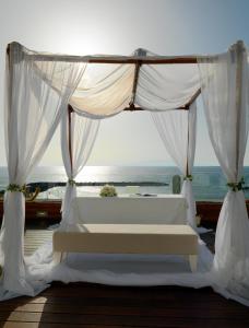 a white canopy bed with a view of the ocean at H10 Gran Tinerfe - Adults Only in Adeje