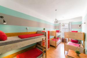 a room with three bunk beds and a room with a table at Hostel Elf in Prague