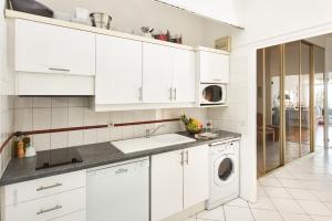 a kitchen with white cabinets and a washer and dryer at Sunlight Properties - "Maryland " - Sea Front in Nice
