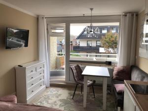 ein Wohnzimmer mit einem Tisch und einem Fenster in der Unterkunft Seerose in Westerland