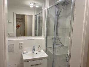 ein weißes Badezimmer mit Waschbecken und Dusche in der Unterkunft Seerose in Westerland