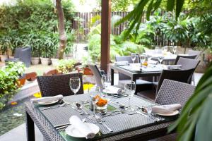 a table with plates and glasses on a patio at Udman Hotel Panchshila Park in New Delhi