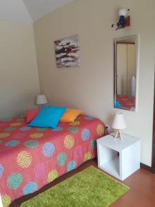 sypialnia z łóżkiem, lustrem i zielonym dywanem w obiekcie Panoramic Ocean View House w mieście Faial