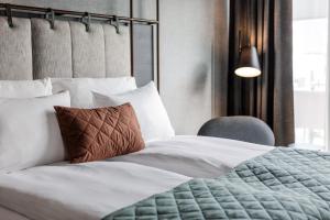 1 dormitorio con 1 cama y 1 silla en Quality Hotel Hasle Linie en Oslo