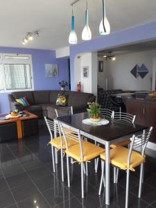 a dining room and living room with a table and chairs at Panoramic Ocean View House in Faial