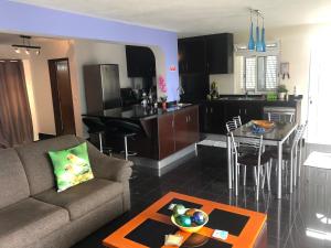 a living room and kitchen with a couch and a table at Panoramic Ocean View House in Faial