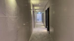 un pasillo con paredes blancas y un largo pasillo con luces en VOK Pension, en Neunkirchen am Sand