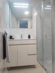 een witte badkamer met een wastafel en een douche bij Barcia 3 in Pontevedra