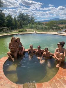 a group of women sitting in a swimming pool at Podere La Piscina- Acqua Termale e Relax in San Casciano dei Bagni